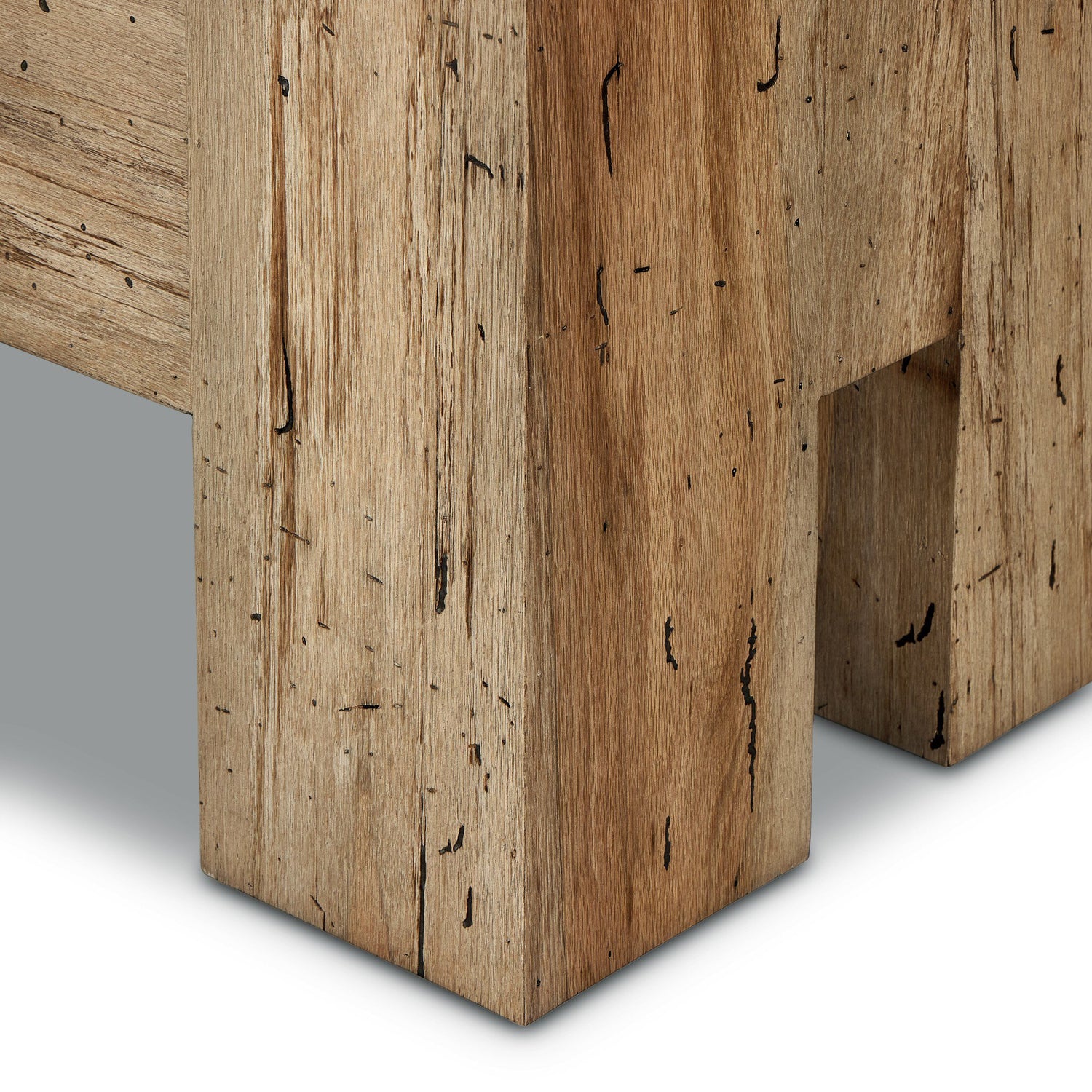 Close-up view of Abaso Accent Bench legs, showcasing thick-cut oak veneer with rustic wormwood-like finish. Chunky squared legs with visible wood grain, knots, and distressed details, emphasizing the bench's sturdy construction and natural, rustic aesthetic.