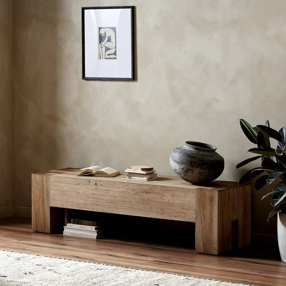 Rustic oak veneer accent bench with clean lines and chunky legs, displayed in minimalist room setting with decorative elements like framed art, pottery, and plants